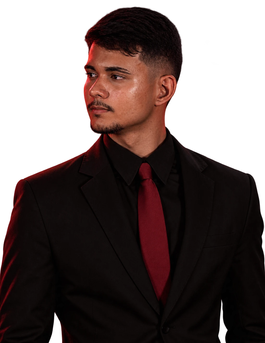 Retrato de Ycaro Vagner, de terno preto e gravata vermelha, olhando para a esquerda